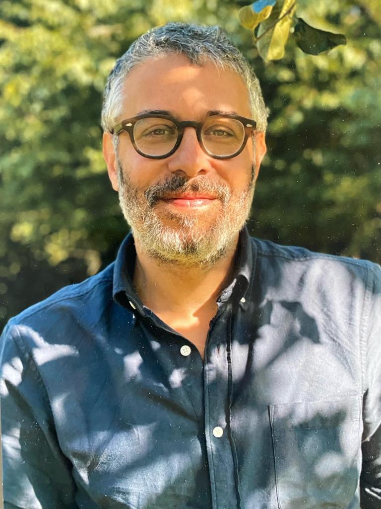 A man wearing glasses and a blue shirt.